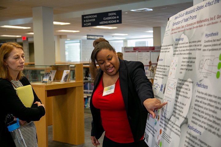 Image of a student presenting a poster to a faculty member